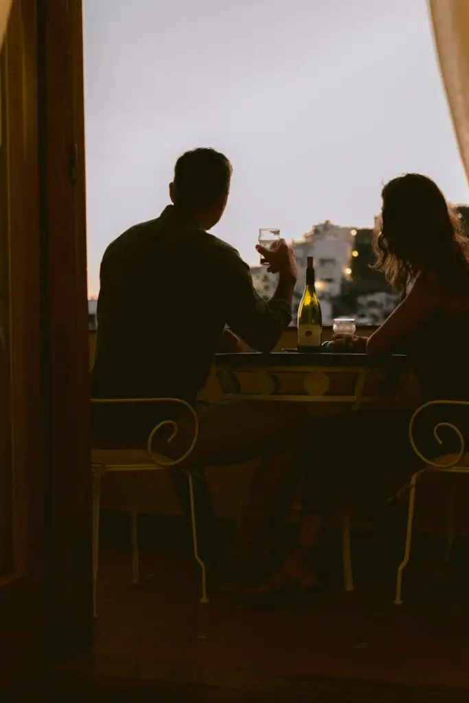 Stel drinkt wijn op een balkon bij zonsondergang