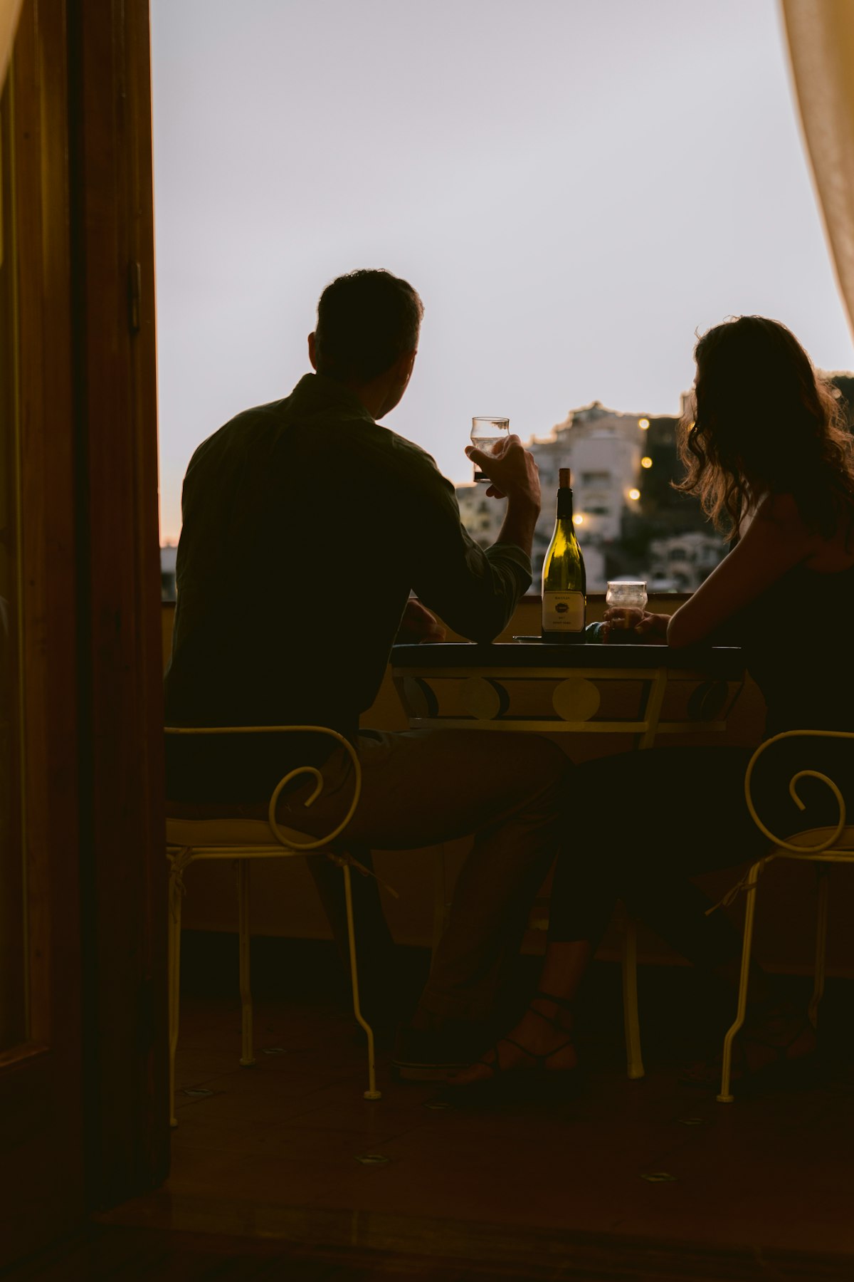 Wijn drinken op een balkon bij zonsondergang